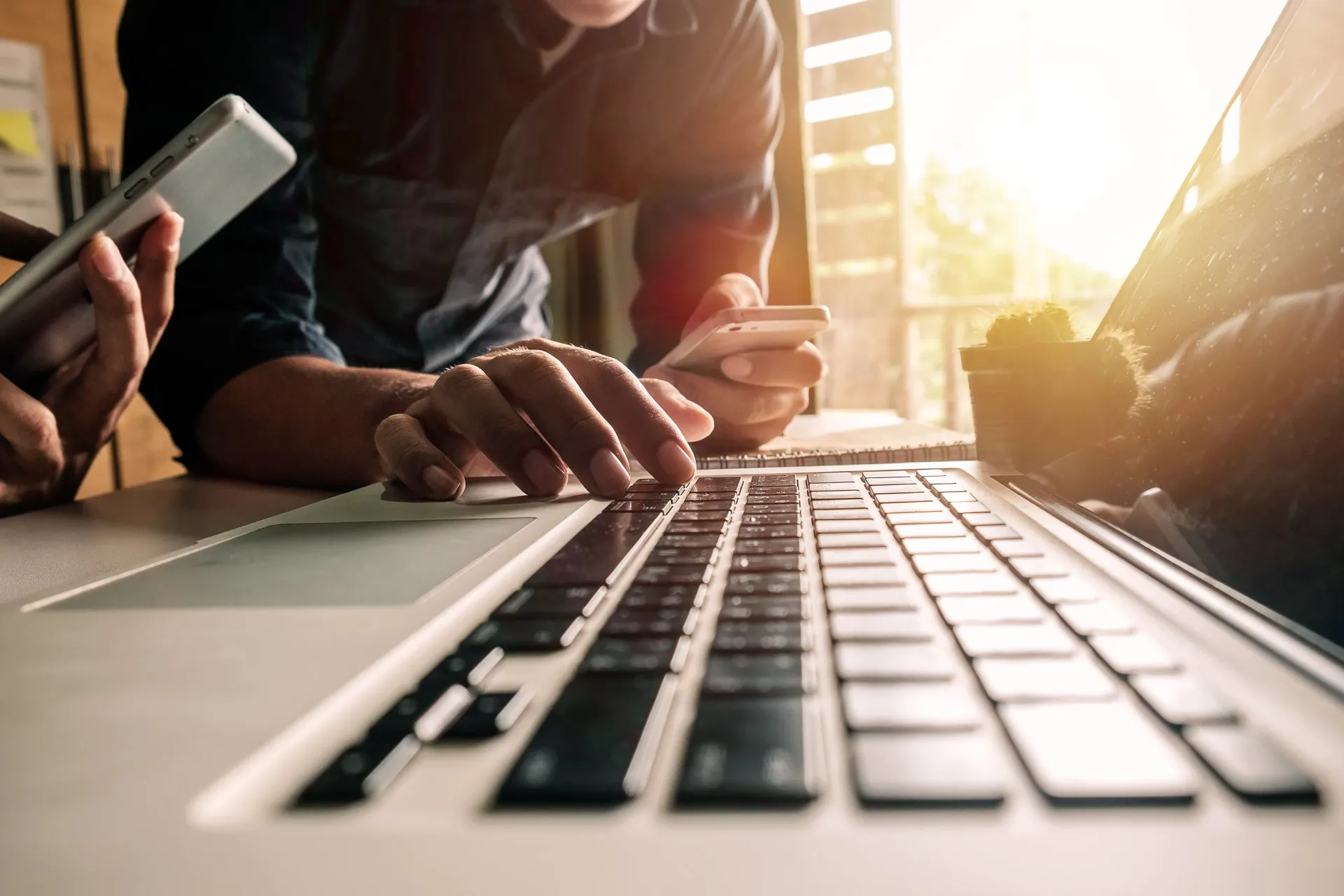 Hände an Laptop und Handy